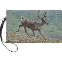 Caribou deer running on a hill in alaska Wristlet Purse