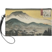Evening view of a temple in the hills by Ando H. Wristlet Clutch
